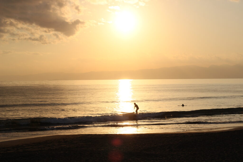 レタッチ前の湘南の夕日とサーファーの写真